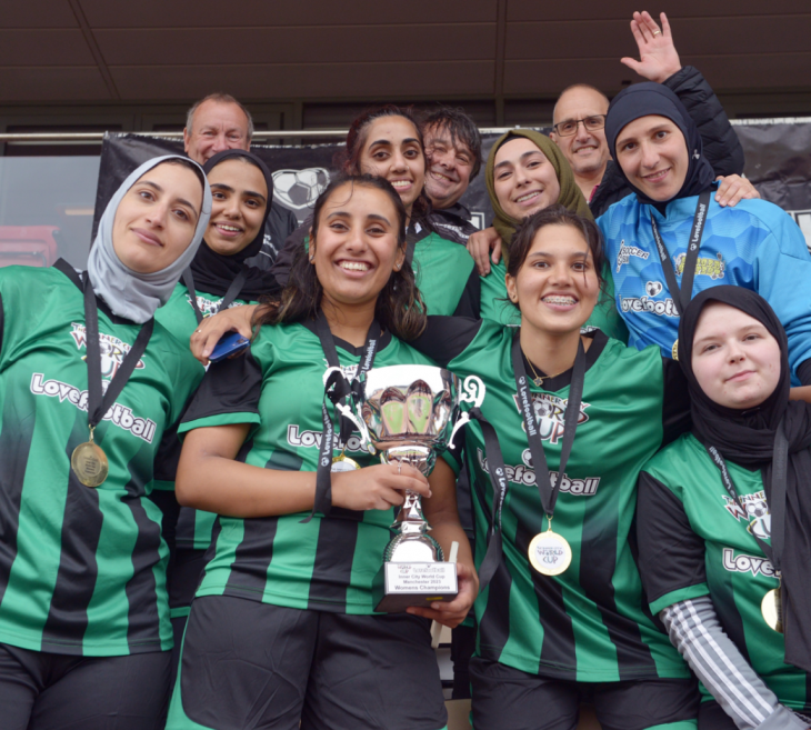 Group of female footballers holding a trophy